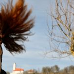 a person with the hair blowing in the wind